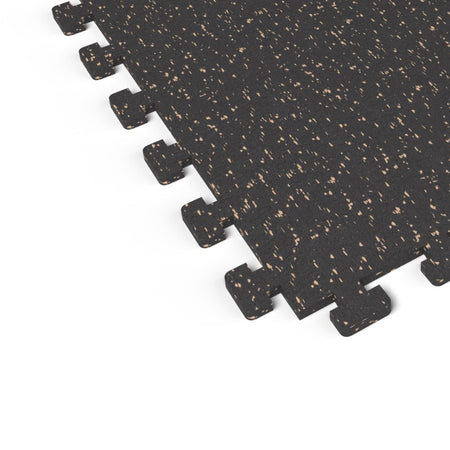 Close-up of the puzzle-edge interlock on a Titan Tan REGUPOL aktivlok rubber gym tile showing tan flecks on a black base